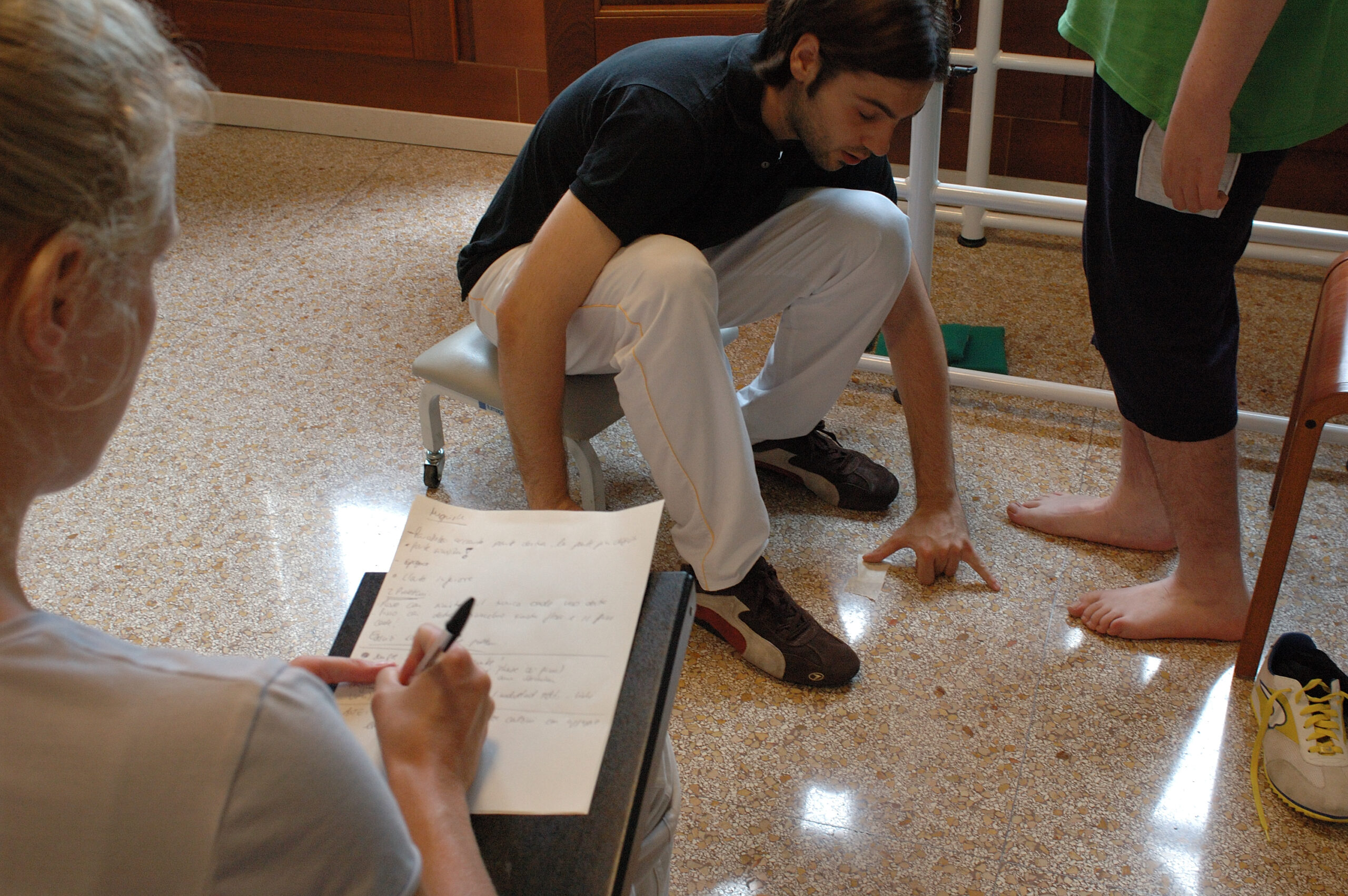 Valerio Sarmati performing exercises with Michele while the mother takes notes